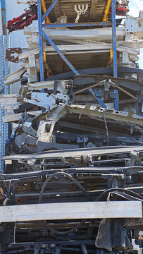 Industrial salvage yard with stacked car parts, showing vehicle dismantling and raw material recycling. Focus on automotive waste