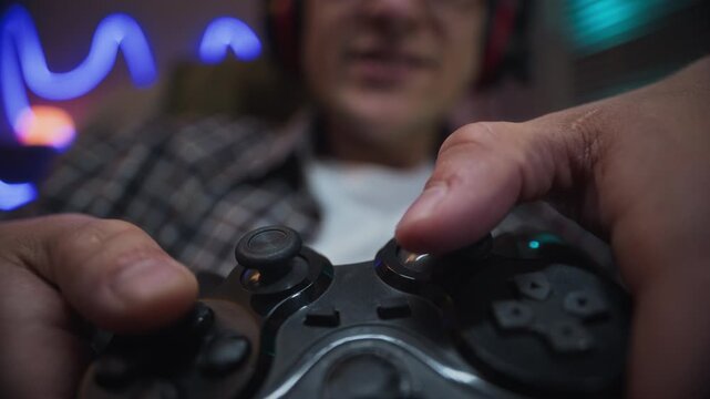 Caucasian young man playing video games, pressing buttons on controller in extreme close up. Footage is suitable for commercial campaigns on gaming addiction or esports