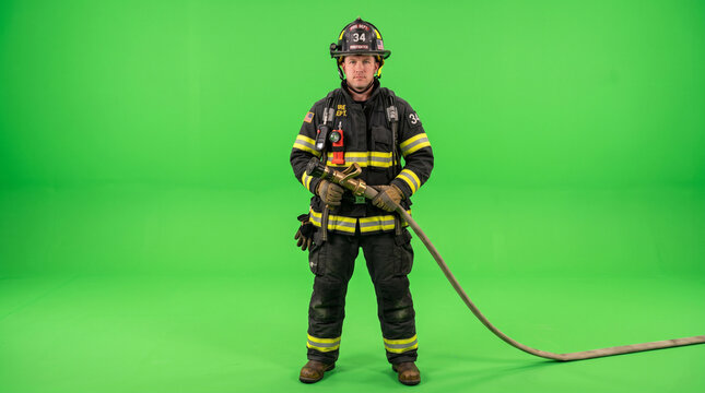 Firefighter in full turnout gear holding a hose on green screen