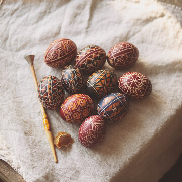Ukrainian pysanky eggs with wooden spoon on rustic linen cloth
