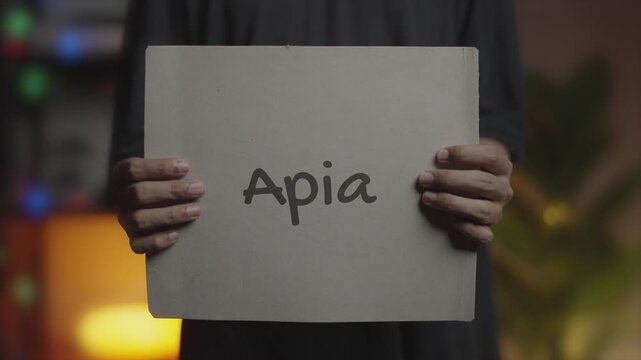 Apia written on Banner &ndash; Man Holding Placard