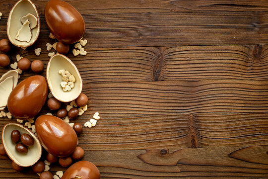 A pile of chocolate eggs and candies, top view. Chocolate background