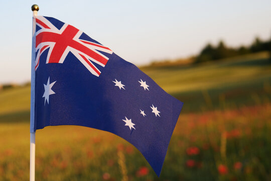 Australian flag waving against sunset field sky