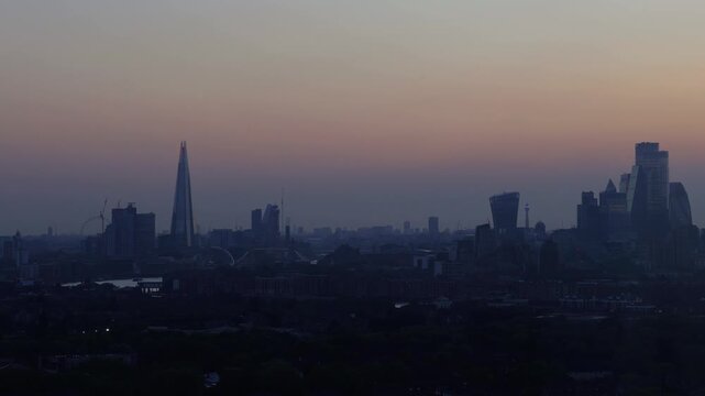 Horizontal 4K timelapse video capturing the day to night transition over the London skyline, revealing the glowing city lights of The Shard, Tower Bridge and financial district