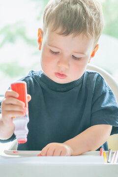 Natural unposed photo of a toddler developing creativity through an artistic activity.