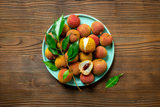 Plate full of exotic lychee fruit with green leaves, top view. Healthy vegetarian meal ready to eat