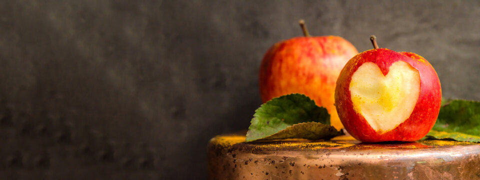 thanksgiving harvest autumn autumanl food photography background - Apple with carved heart shape symbol, isolated on black concrete wall