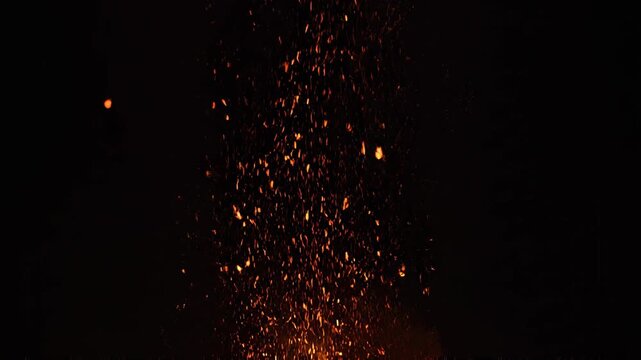 Glowing embers rising against dark background with subtle camera drift and bokeh effect
