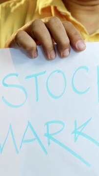 Concept of returns on saving - Indian Asian woman in her fifties with grey hair sits on the sofa, holding a piggy bank in surprise as Indian five-hundred rupee notes rain down around he