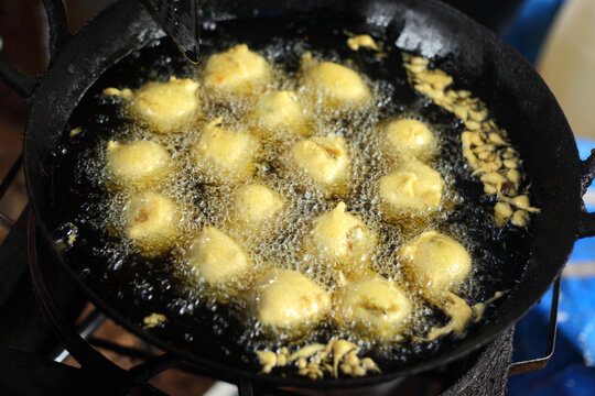 Indian style vada being deep-fried in hot oil, a traditional savory snack commonly enjoyed as street food and breakfast in India.