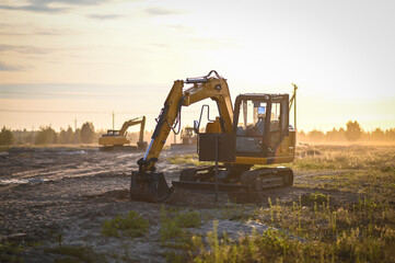 Mini excavator working at a construction site, digging and moving soil. Compact heavy machinery used for excavation, landscaping, and site preparation. © senssnow