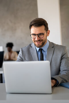 Business man at a desk working on his laptop, focused on his digital workspace in an office setting