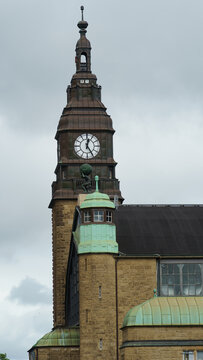 View of the clock tower of the Hamburg Rathaus featuring the Atlas statue holding up the globe against a cloudy sky in Hamburg, Hamburg, Germany.