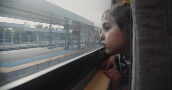 Little girl looks out the train window on the way to Toronto airport