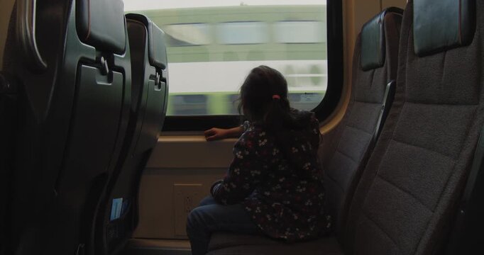Girl looks out train window heading to Toronto airport
