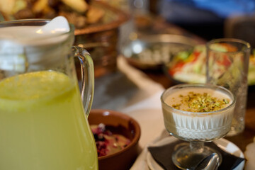 Obraz premium Family gathering for iftar during Ramadan with traditional dishes and drinks served on the table