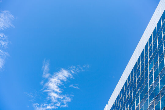 Glass Facade Office Building Under Blue Sky for Modern Architecture Corporate Vision and Real Estate Investment Background, Low Angle Perspective Photo with Copyspace