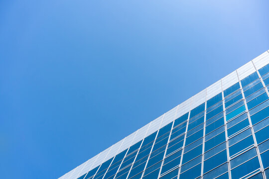 Glass Facade Office Building Under Blue Sky for Modern Architecture Corporate Vision and Real Estate Investment Background, Low Angle Perspective Photo with Copyspace