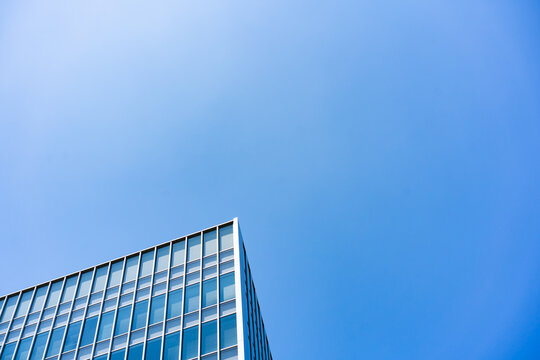 Glass Facade Office Building Corner Under Blue Sky for Modern Architecture Corporate Growth and Real Estate Investment Background, Low Angle Perspective Photo with Copyspace