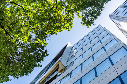 Green Building Modern Office Facade with Green Tree Canopy for Corporate ESG Sustainability and Eco Friendly Urban Real Estate Development, Low Angle Perspective Photo