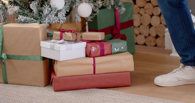 Father and daughter-child seeing gold gift as father picking gift by tree in Santa hat surprising