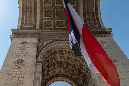 Paris, France: Arc de Triomphe in Paris with a big French flag under it