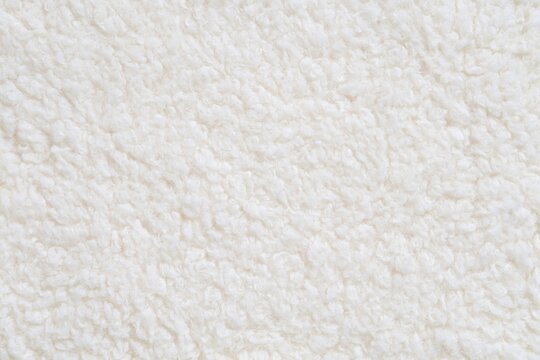 Fabric texture of soft white sherpa fleece material for cozy fluffy textile design