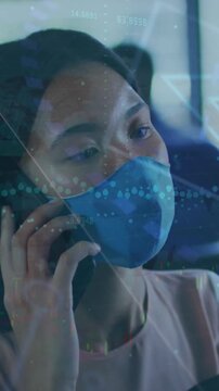 Animation of data processing over asian businesswoman with face mask talking on smartphone