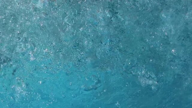 Pool water surface churning and bubbling in swimming pool