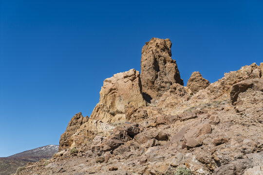 View of the volcanic rock formations of Mount Teide under a clear blue sky in Santa Cruz de Tenerife, Canary Islands, Spain.