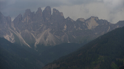 Obraz premium Majestic scenery of rough mountain ridge near grassy hills 