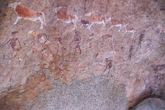 Mehrere pr&auml;historische Tier- und Menschenfiguren bedecken eine Felswand an der White Lady St&auml;tte im Brandberg in Namibia.