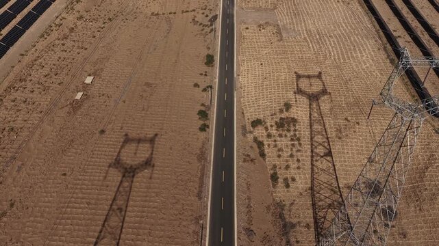High-voltage Power Transmission Towers and Solar Farm Along Asphalt Road in Gobi Desert, Northwest China