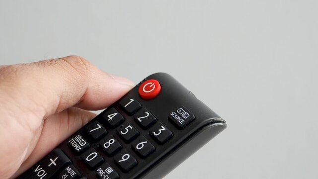 Thumb pressing power button on tv remote control