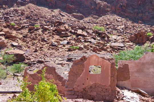 Zerfallene Lehmw&auml;nde stehen vor einem steinigen Hang in trockener Landschaft bei Vingerklip, Namibia.