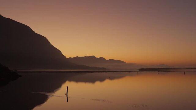 4K 30fps footage of a tranquil sunrise over the Kleinrivier Estuary and Kleinrivier Mountains near Hermanus on South Africa&rsquo;s Whale Coast. Dawn light reflects on calm waters in the Overberg region.