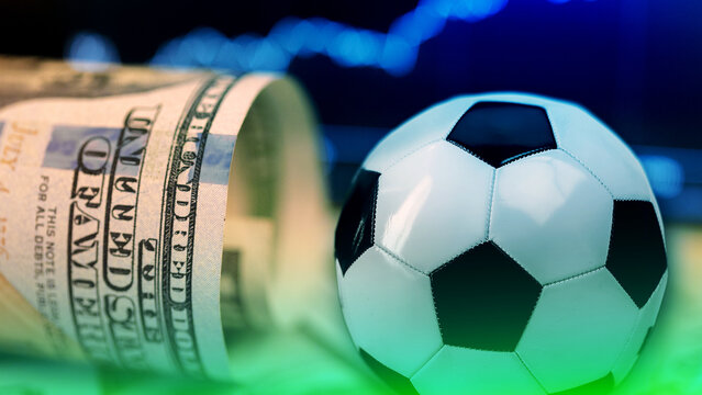 Sport betting with cash and a soccer ball on a table during an event
