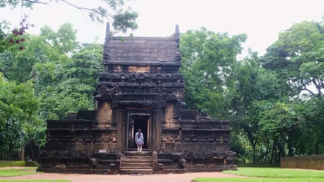 Tourist entering ancient stone temple Nalanda Gedige in Sri Lanka