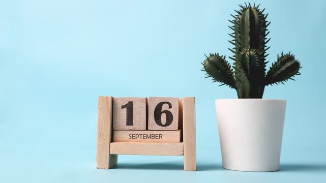 Month of September wooden block calendar timelapse with a plastic cactus on the side.