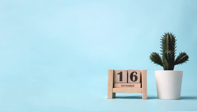 Month of September wooden block calendar timelapse with a plastic cactus on the side.