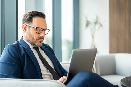 Businessman using laptop for legal work in office, focusing on business administration, accounting tasks, and financial management in a modern workspace