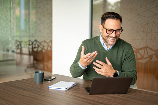 Entrepreneur having a lively remote meeting using a notebook computer, actively communicating with team members and clients in a corporate setting
