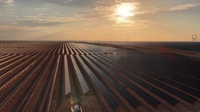 Stunning Sunset over Vast Solar Panel Farm in Remote Sandy Desert Landscape