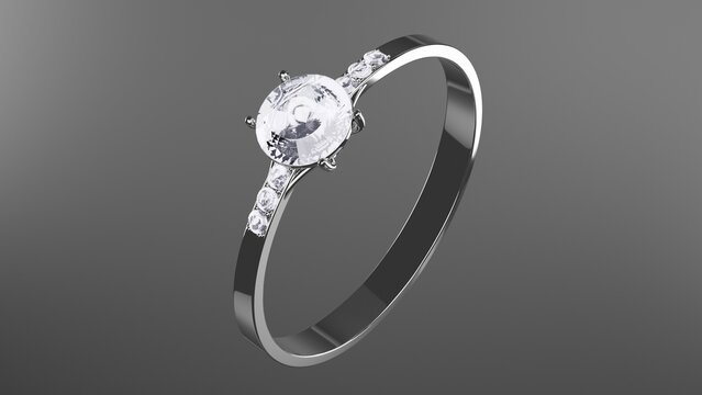 Elegant gemstone ring displayed from an angled perspective, featuring a polished metallic band and faceted central stone with reflective studio lighting on a dark neutral background.