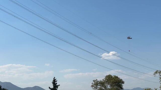 Firefighting helicopter drops water over a wildfire in Antalya, Turkey, during an aerial emergency response operation.