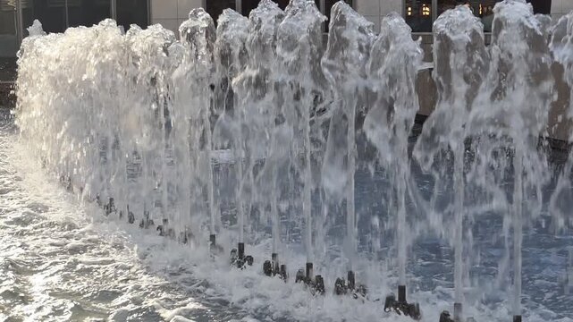 A row of vertical water fountain jets spraying upward in a line.&nbsp;