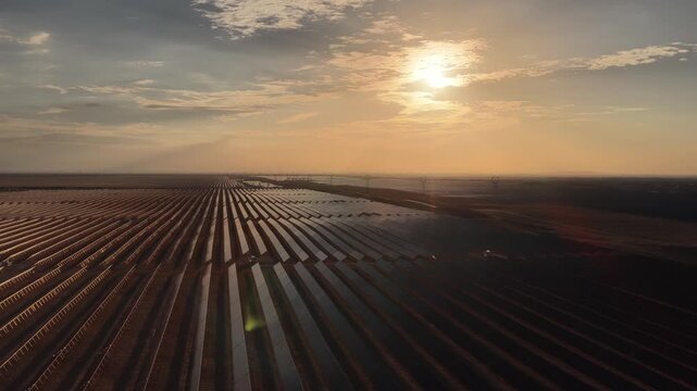 Stunning Sunset over Vast Solar Panel Farm in Remote Sandy Desert Landscape