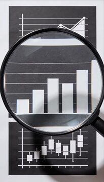 Fintech data visualization analysis chart graph magnifying glass business finance market report page with finance analytics, bar graph and candlestick chart paper for market trend performance