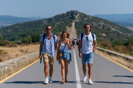 Friends walking on a long road in mountains