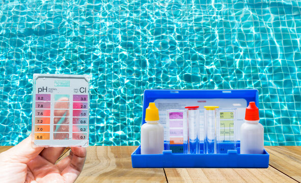 Water tester test kit in girl hand over blurred swimming pool water background, quality water testing test kit, pool maintenance and service business concept